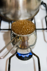 Turkish coffee pot and coffee boiling on gas stove, strong drink