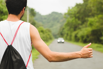 Backpacker tourist hitchhiking on mountain road in Vietnam