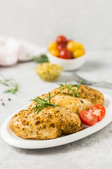 Baked mustard honey chicken breasts with cherry tomatoes. Selective focus, space for text.