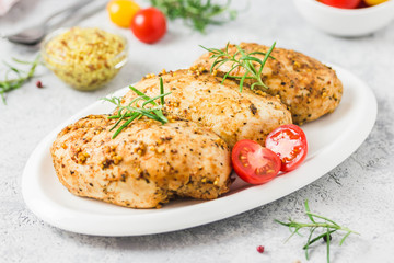 Baked mustard honey chicken breasts with cherry tomatoes. Selective focus, space for text.