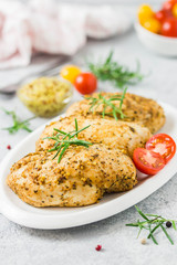 Baked mustard honey chicken breasts with cherry tomatoes. Selective focus, space for text.