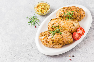 Baked mustard honey chicken breasts with cherry tomatoes. Top view, space for text.