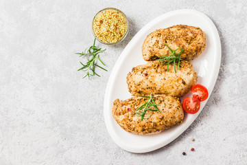 Baked mustard honey chicken breasts with cherry tomatoes. Top view, space for text.