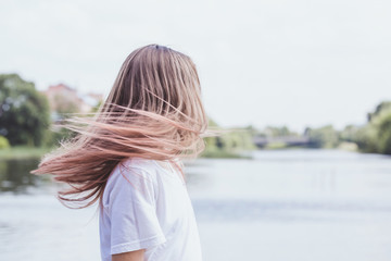 Beautiful girl with ash-pink hair waving her head by the river