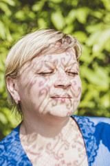 The shadow of lace on the face of a adult woman