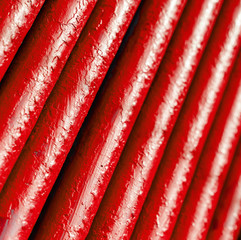 Many old red pipes. Pipeline used in different industry ways: gas, water or vapor supply. Close up