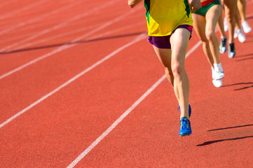 Athletics people running on the track field. Sunny day