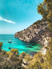 View from above of the beautiful Cala Blanca, Andratx with a turquoise waters  and spanish nature landscape with blue bright summer sky. Mallorca, Balearic Islands