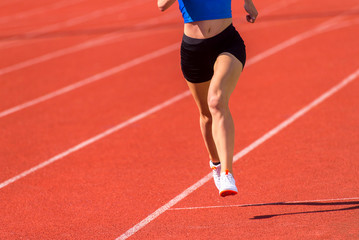 Obraz premium Young sporty woman running on sunny day