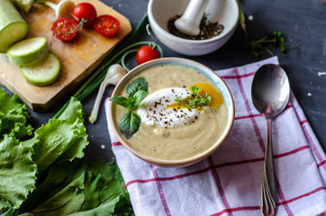 Healthy zucchini cream soup served with poached egg and greens. Proper nutrition food