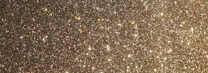 blur glitter or bokeh gold festive background,  texture banner, panoramic. Xmas abstract background with copy space.