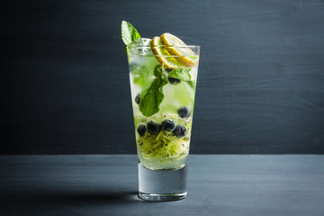 Fresh summer cocktail with blueberry and kiwi on the wooden background. Selective focus. Shallow depth of field. 