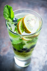 Fresh summer cocktail with blueberry and kiwi on the wooden background. Selective focus. Shallow depth of field. 