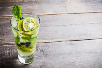 Fresh summer cocktail with blueberry and kiwi on the wooden background. Selective focus. Shallow depth of field. 