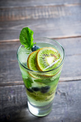 Fresh summer cocktail with blueberry and kiwi on the wooden background. Selective focus. Shallow depth of field. 