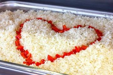 Boiled rice decorated with a heart of red pepper