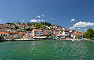 Fototapeta na wymiar Ochrid, Macedonia: toursit walking and enjoing in the view of old part of Ochrid city on a boat dock on a Ochrid lake
