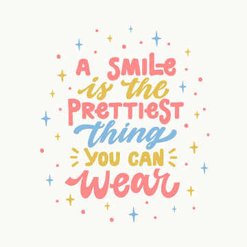 A smile is the prettiest thing you can wear. Iinspirational hand drawn lettering quote. In bright blue, pink, yellow colors. Motivational phrase. T-shirt print, poster, postcard, banner design. Female