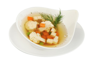 Vegetable soup with cauliflower, potatoes, peas, carrots and dill on a white isolated background