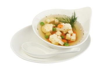 Vegetable soup with cauliflower, potatoes, peas, carrots and dill on a white isolated background