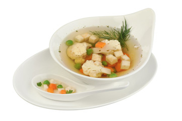 Vegetable soup with cauliflower, potatoes, peas, carrots and dill on a white isolated background