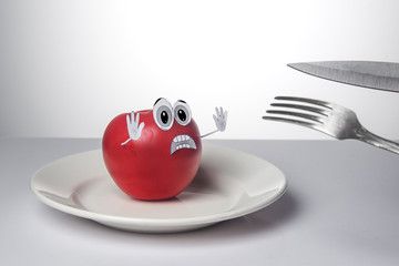 Scared tomato, sad tomato. Vegetarian concept. Vegetable abuse.
