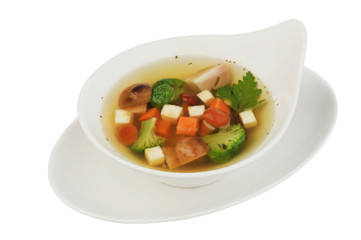 Vegetable soup with cauliflower, potatoes, peas, carrots and parsley on a white isolated background