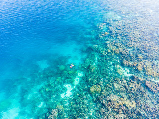 Aerial top down people snorkeling on coral reef tropical caribbean sea, turquoise blue water. Indonesia Banyak Islands Sumatra, tourist diving travel destination.