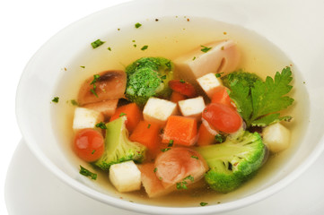 Vegetable soup with cauliflower, potatoes, peas, carrots and parsley on a white isolated background