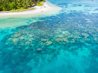 Aerial top down people snorkeling on coral reef tropical caribbean sea, turquoise blue water. Indonesia Banyak Islands Sumatra, tourist diving travel destination.
