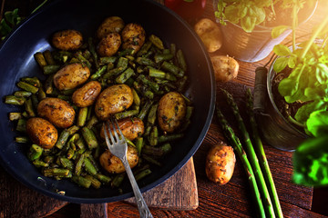 Potatoes fried with asparagus in a pan with spices
