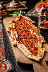 Traditional Turkish cuisine. Turkish pizza Pita with meat. Turk Pidesi or  Sucuk Pide. Beautiful serving dishes in the restaurant. Background image. copy space