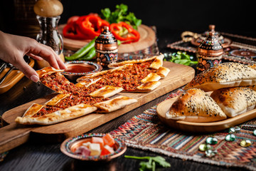 Traditional Turkish cuisine. Turkish pizza Pita with meat. Turk Pidesi or  Sucuk Pide. Beautiful serving dishes in the restaurant. Background image. copy space - obrazy, fototapety, plakaty