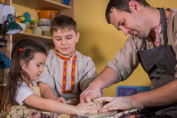 Potter showing how to work with ceramic in pottery studio