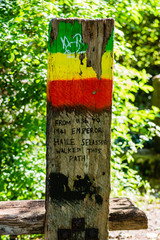 A wooden post next to a bench in tribute to Haile Selassie in the city of Bath