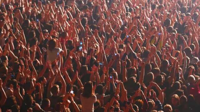 crowd enjoys listening concert claps hands and takes photos