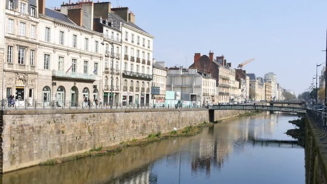 Time lapse in Rennes, a city in Brittany, France. View on the quays of the Rivi&egrave;re de la Vilaine. Filmed on a sunny day. Reflections of the buildings on the river. Street traffic.