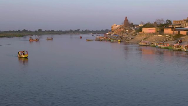 Ganga river ghat with boats in India, Vrindavan, 4k aerial drone sunset