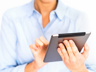 Young businesswoman in shirt using her tablet on white background