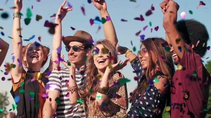 Group of friends dancing in confetti