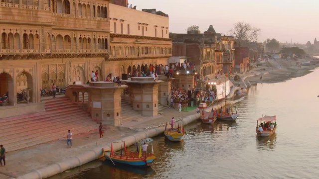 Ganga river ghat with boats in India, Vrindavan, 4k aerial drone sunset