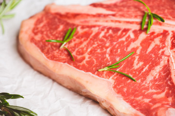 Raw fresh marble T-bone meat on the rustic background. Selective focus. Shallow depth of field.