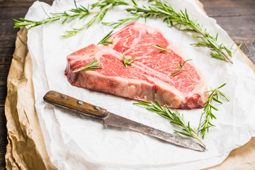 Raw fresh marble T-bone meat on the rustic background. Selective focus. Shallow depth of field.