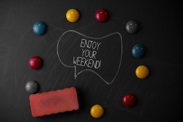 Handwriting text writing Enjoy Your Weekend. Conceptual photo wishing someone that something nice will happen at holiday Round Flat shape stones with one eraser stick to old chalk black board