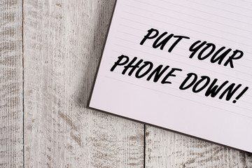 Conceptual hand writing showing Put Your Phone Down. Concept meaning end telephone connection saying goodbye caller Notebook stationary placed above classic wooden backdrop