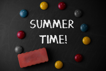 Word writing text Summer Time. Business photo showcasing achieve longer evening daylight summer setting clocks hour ahead Round Flat shape stones with one eraser stick to old chalk black board