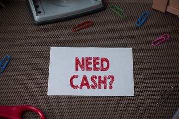 Conceptual hand writing showing Need Cash Question. Concept meaning asking someone if you need extra money or dont Scissor and writing equipments sheet above textured backdrop