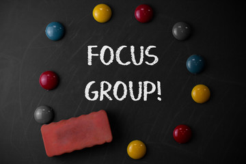 Word writing text Focus Group. Business photo showcasing showing assembled to participate in discussion about product Round Flat shape stones with one eraser stick to old chalk black board