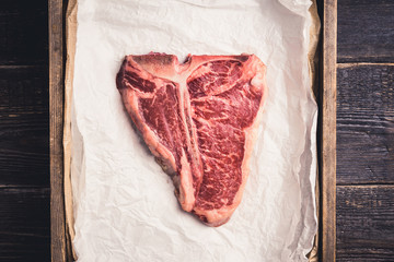 Raw fresh marble T-bone meat on the rustic background. Selective focus. Shallow depth of field.