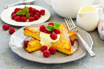 French toast with english sauce and raspberries.